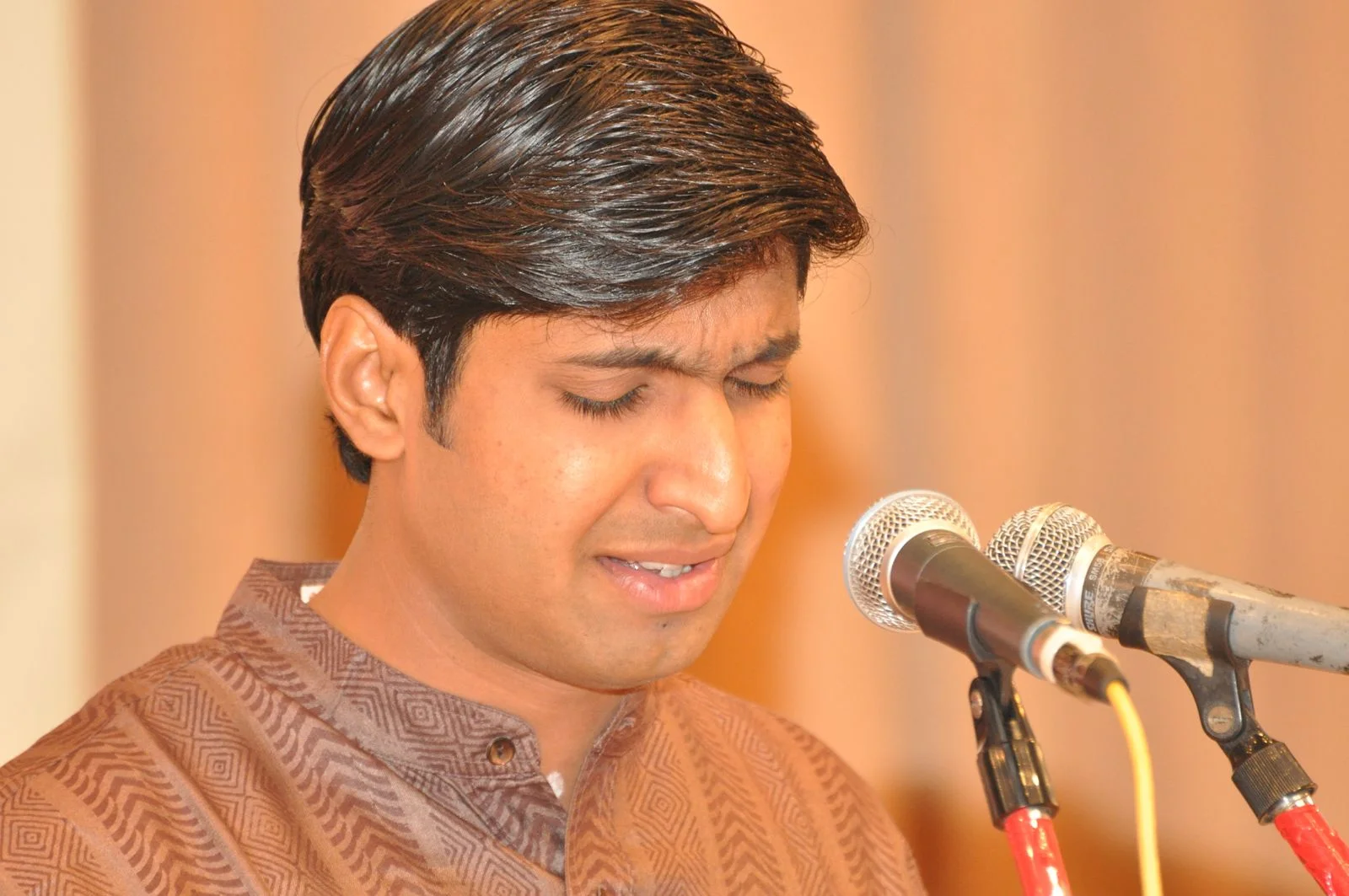 Close-up of Dr. Koustubh Pare immersed in soulful singing at the microphone