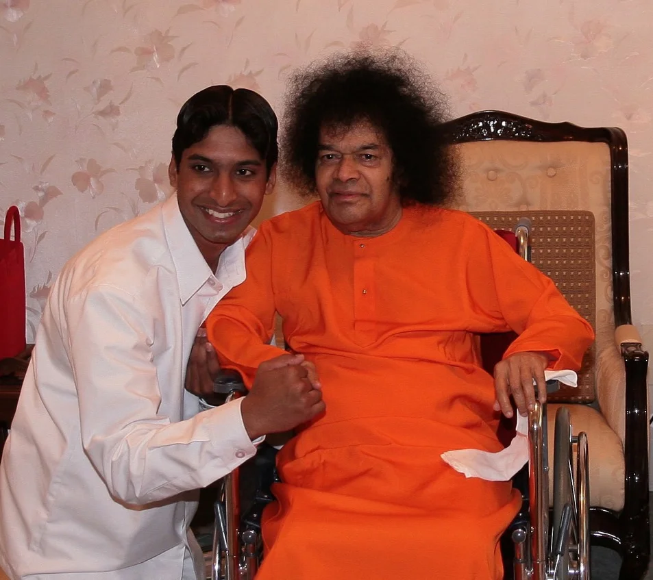 A young Dr. Koustubh Pare holding hands with Bhagawan Sri Sathya Sai Baba