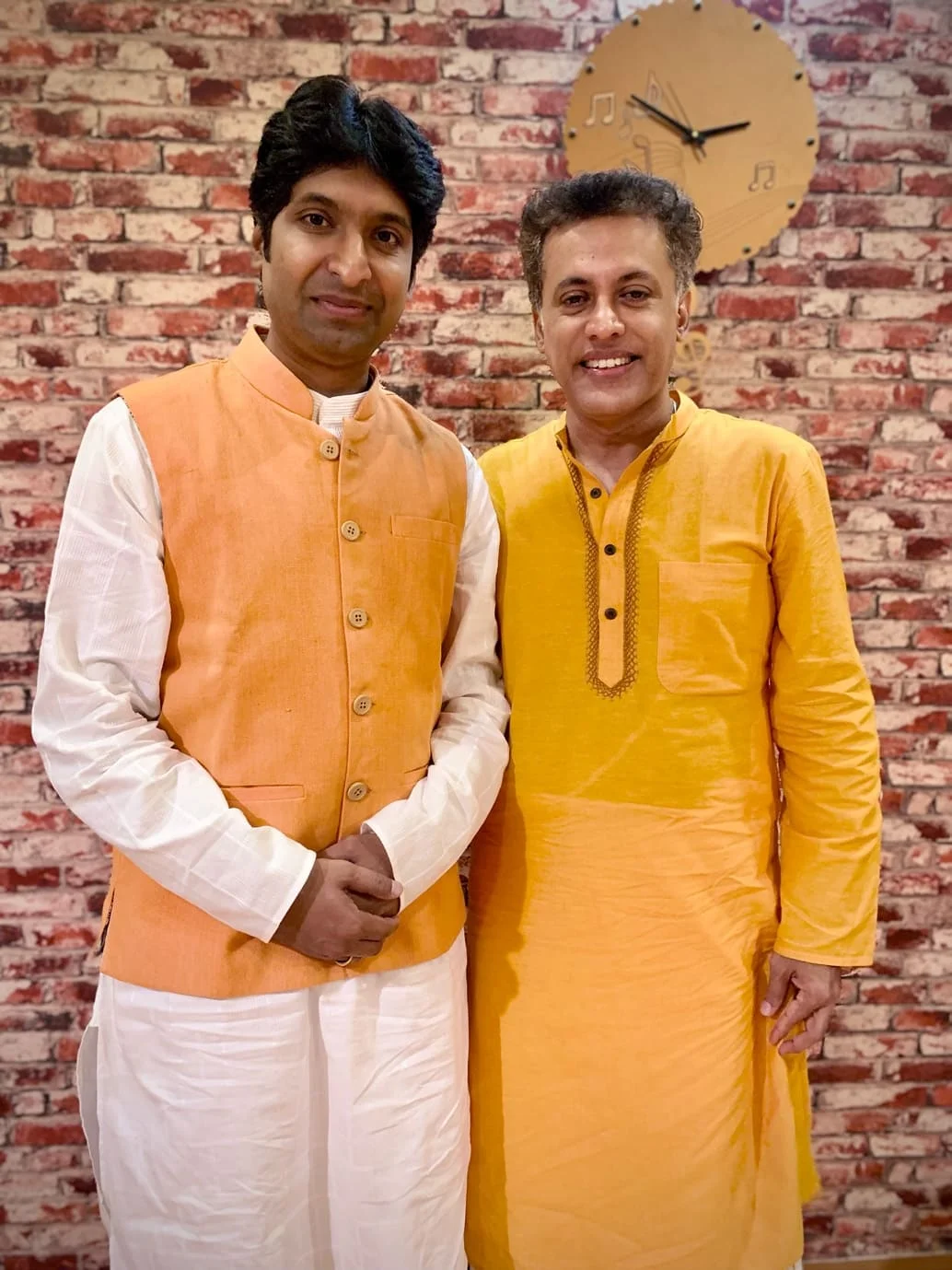Dr. Koustubh Pare with a fellow artist against a brick wall